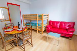 a living room with a red couch and a table at City Center Holiday Apartment in Interlaken