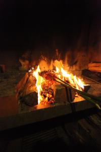 ein Feuer in einem Steinofen mit Flammen in der Unterkunft Casa do Ribeirinho in Porto Moniz