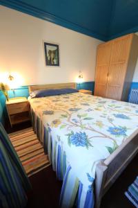 1 dormitorio con 1 cama grande con colcha de flores en Casa do Ribeirinho, en Porto Moniz