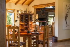 una sala da pranzo con tavolo e sedie in legno di Challhuaquen Lodge a Trevelin