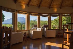 una sala de estar con un montón de ventanas en Challhuaquen Lodge en Trevelín