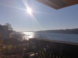 una vista de un cuerpo de agua con el sol brillando en Dom nad jeziorem Mikołajki, en Mikołajki