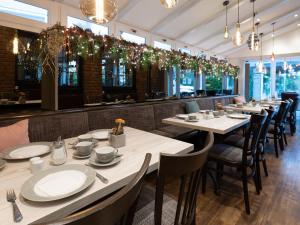 a dining room with tables and chairs and lights at Hotel im Park in Haan
