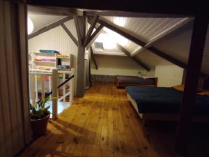 ein Zimmer mit einem Bett und einem Sofa im Dachgeschoss in der Unterkunft Maison Landaise chaleureuse in Rion-des-Landes