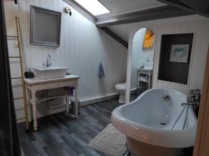 ein Badezimmer mit einem Waschbecken, einer Badewanne und einem WC in der Unterkunft Maison Landaise chaleureuse in Rion-des-Landes