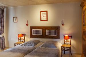 a bedroom with two beds and two chairs and two lamps at Gîte La Glycine in Cosswiller