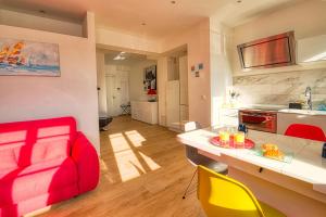 Il comprend un salon avec un canapé rouge et une cuisine. dans l'établissement Suite Neptune, à Nice