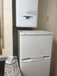 a white refrigerator with a microwave on top of it at Saldaña. Apartamento in Saldaña