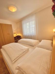 two twin beds in a room with a window at Villa Lory in Canazei