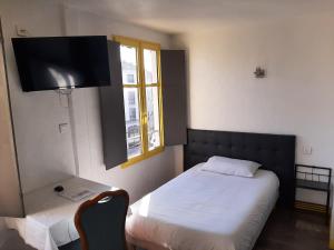 um pequeno quarto com uma cama e uma janela em Hôtel Les Beaux Arts- Limoges Hypercentre em Limoges