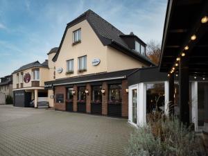 a store front of a building with a parking lot at Hotel im Park in Haan