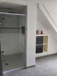 een glazen douchedeur in een kamer met een trap bij Payrac LOT in Payrac