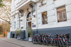 una fila di biciclette parcheggiate di fronte a un edificio di The Lancaster Hotel Amsterdam ad Amsterdam