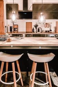 a kitchen with a wooden counter and two stools at FLYGGE Apartments in Altusried