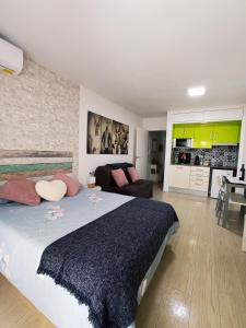 een slaapkamer met een groot bed en een woonkamer bij Apartamento con piscina a 2 minutos de la playa!!! in Lloret de Mar