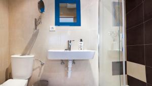 a bathroom with a toilet and a sink and a shower at Pensión Herradores in Soria