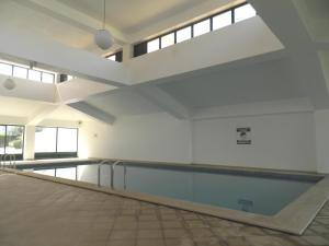 una piscina vacía en un edificio con techo en Jardins de Santa Eulália By Albufeira Rental, en Albufeira