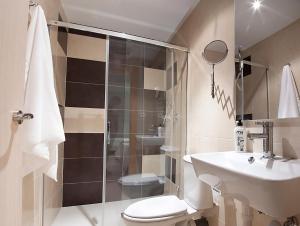 a bathroom with a shower and a toilet and a sink at Pensión Herradores in Soria +10 photos