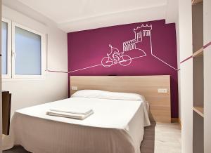ソリアにあるPensión Herradoresの紫の壁の白いベッドが備わるベッドルーム1室