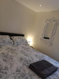 a bedroom with a bed with a mirror on the wall at Westmoreland Cottage in Weaverthorpe