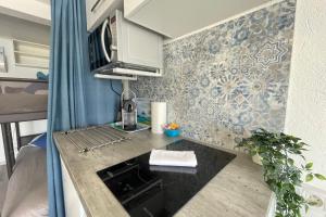 a small kitchen with a counter and a microwave at Le Vrai Cabanon de la Plage Clim-Wifi-Netflix in Marseille