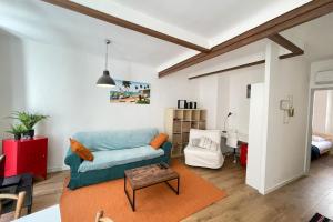 uma sala de estar com um sofá azul e uma mesa em Le Méditerranéen T2 WifiNetflix CityCenter em Marselha