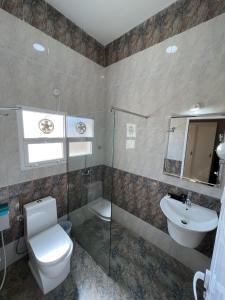 a bathroom with a toilet and a sink at Ibra Plaza Hotel in Ibrā