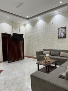 a living room with a couch and a table and a tv at Ibra Plaza Hotel in Ibrā