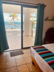 a bedroom with a view of the beach with a bed at CASA PARAÍSO in Xcalak