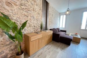a living room with a couch and a stone wall at Atelier des rêvesVieuxPortProche PlagesLaCiotat in La Ciotat