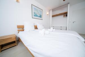 Un dormitorio blanco con una gran cama blanca y una ventana en Rheinblick Penthouse Wolke 7 - Neuss/Düsseldorf en Neuss