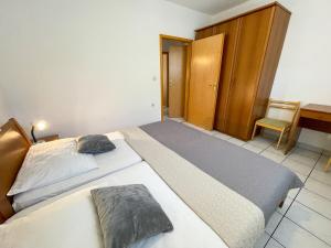 1 dormitorio con 1 cama grande y 1 silla en Villa Ljiljana, en Jadranovo