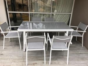 una mesa y sillas blancas con una mesa y sillas blancas en Lacanau Ocean : Maison de vacances dans la Pinede, en Lacanau