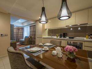 a kitchen with a table and chairs and two lights at Ascott Sentral Kuala Lumpur in Kuala Lumpur