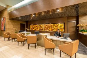 a man sitting at a table with a laptop in a lobby at Ascott Sentral Kuala Lumpur in Kuala Lumpur +35 photos
