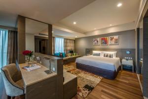 Pokój hotelowy z łóżkiem i biurkiem w obiekcie Ascott Sentral Kuala Lumpur w Kuala Lumpur