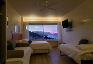 a hotel room with two beds and a large window at CONDOR STUDIO BARILOCHE in San Carlos de Bariloche