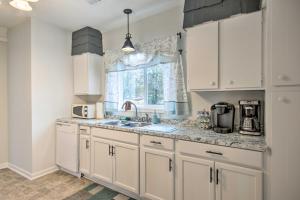 a kitchen with white cabinets and a sink and a window at Traditional Southern House with Front Porch! in Anderson