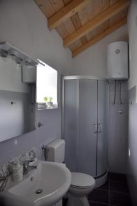 a white bathroom with a toilet and a sink at Pinta Apartments in Lumbarda +37 photos