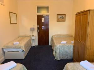 a hotel room with two beds and a desk at St Simeon in London