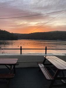 two benches sitting next to a body of water at The Galleon Inn in Fowey