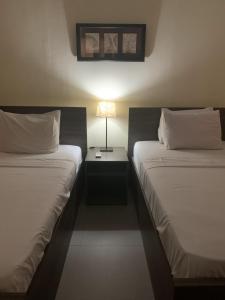 2 camas en una habitación de hotel con una lámpara entre ellas en Sakan 275, en El Cairo