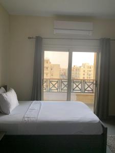 a bedroom with a bed and a large window at Sakan 275 in Cairo