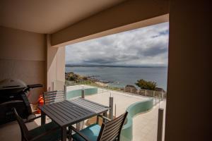 a balcony with a table and chairs and a view of the ocean at Nautica 503 in Mossel Bay