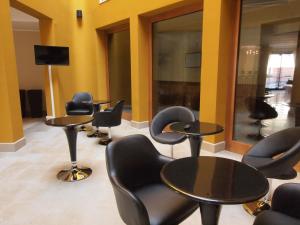 a waiting area with tables and chairs in a salon at Hotel San Rocco in Muggia