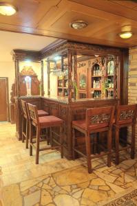 bar z drewnianymi meblami i krzesłami w pokoju w obiekcie Adria w mieście Bieruń Nowy