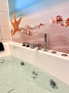 a bathroom sink with a mirror and a starfish at Kaiserliche Hofpost, mit Whirlpool und 2 Terrassen in Schleiden