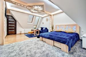 a bedroom with a blue bed in a attic at Willa Pod Grapą in Poronin