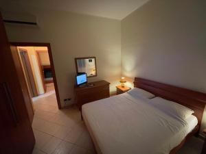 ein Schlafzimmer mit einem Bett, einem Spiegel und einem TV in der Unterkunft Case Eoliane, Panarea in Patti