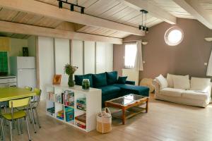 a living room with a blue couch and a table at Les Jardins de La Palaire - Gîte T2 avec jardin in Cugand
